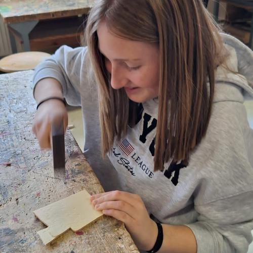 Schülerin bearbeitet Holz