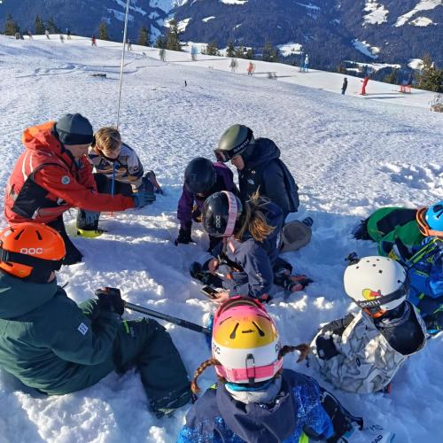 Kinder und Bergretter beim Suchen mit Sonde