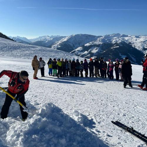 Bergretter schaufelt, Kinder sehen zu