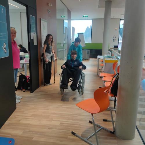 Schüler im Rollstuhl anderer schiebt