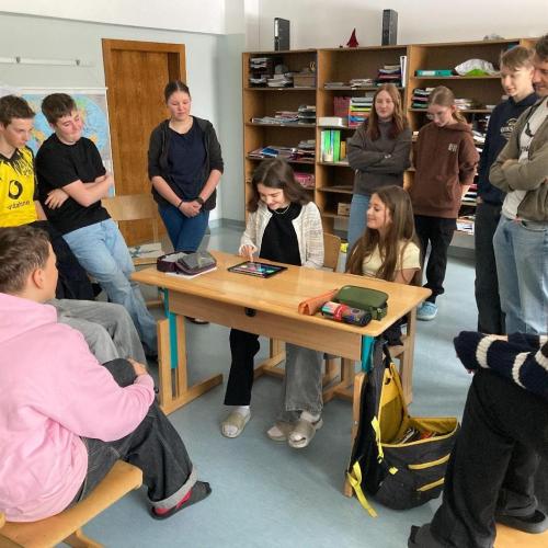 Kinder stehen im Kreis um einen Tisch herum