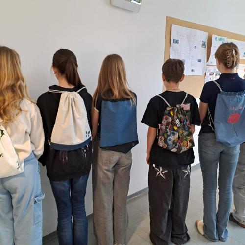 Schüler in einer Reihe mit Rucksäcken