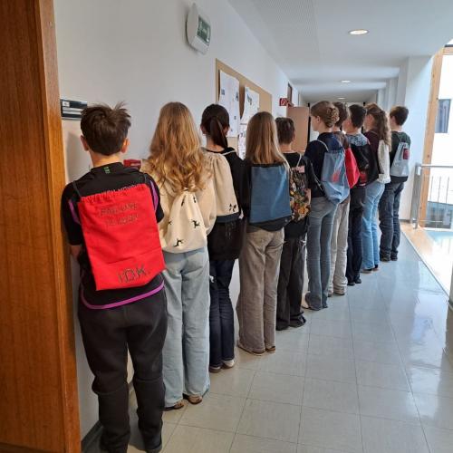 Schüler in einer Reihe mit Rucksäcken