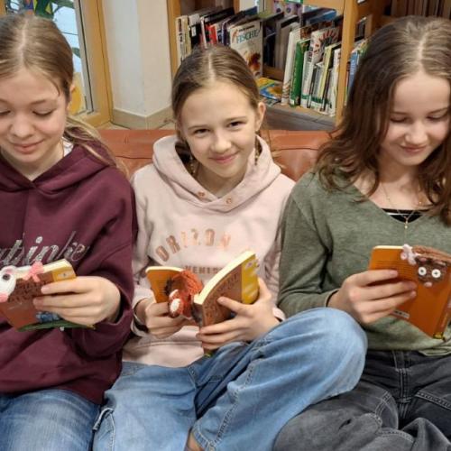 Mädchen beim Lesen mit tierischen Lesezeichen