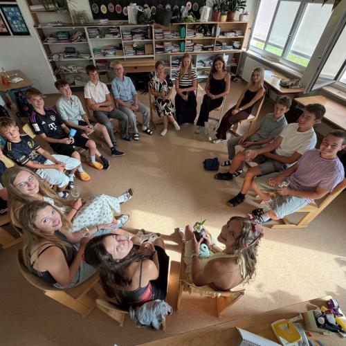 Kinder sitzen im Kreis beim Rätseln