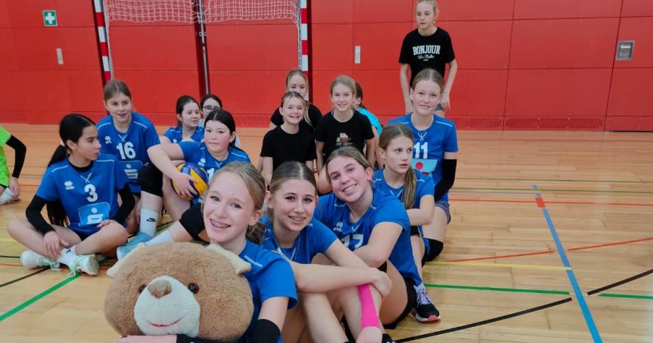 Schülerinnen sitzend mit Maskottchen