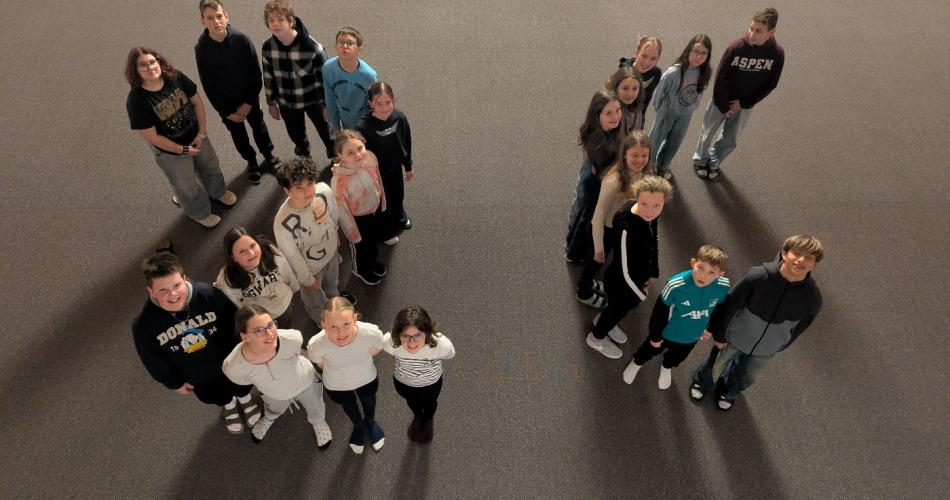 Kinder in der Aula bilden die Formen 2c