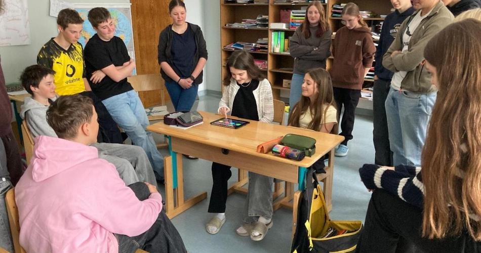 Kinder stehen im Kreis um einen Tisch herum