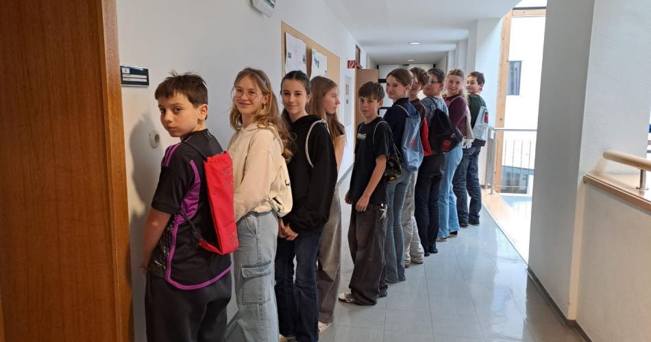 Schüler in einer Reihe mit Rucksäcken